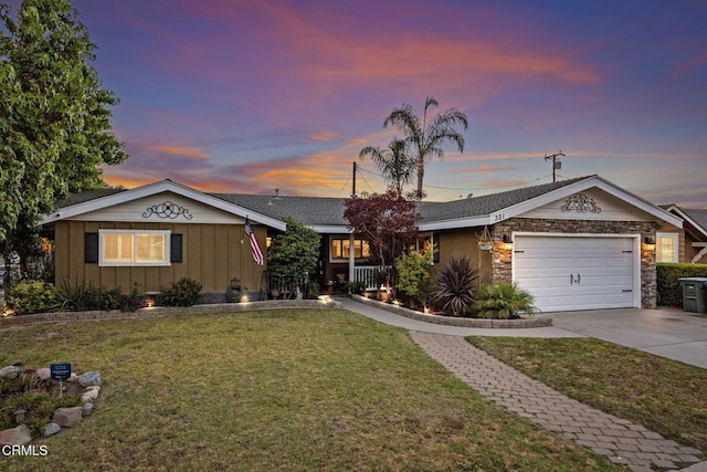 single story home featuring a lawn and a garage