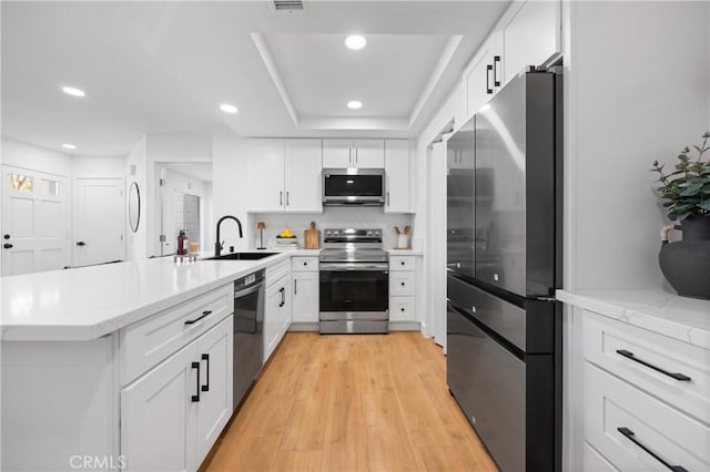 kitchen with appliances with stainless steel finishes, white cabinets, and sink