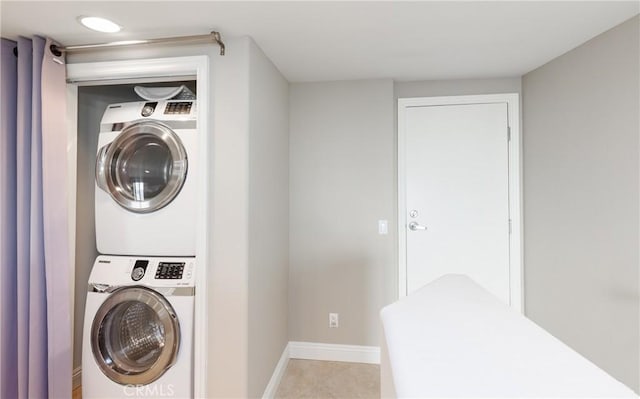 washroom featuring light tile patterned floors and stacked washer and clothes dryer