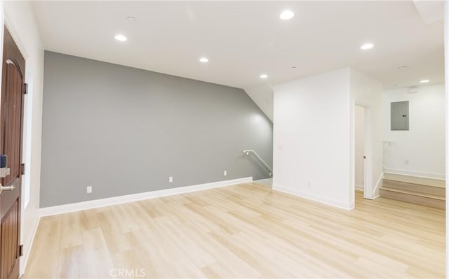 spare room with electric panel and light wood-type flooring