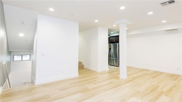 interior space with light hardwood / wood-style floors and stainless steel fridge with ice dispenser