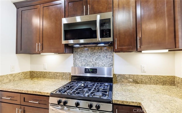 kitchen with appliances with stainless steel finishes and light stone counters