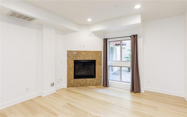 unfurnished living room featuring hardwood / wood-style flooring and a fireplace