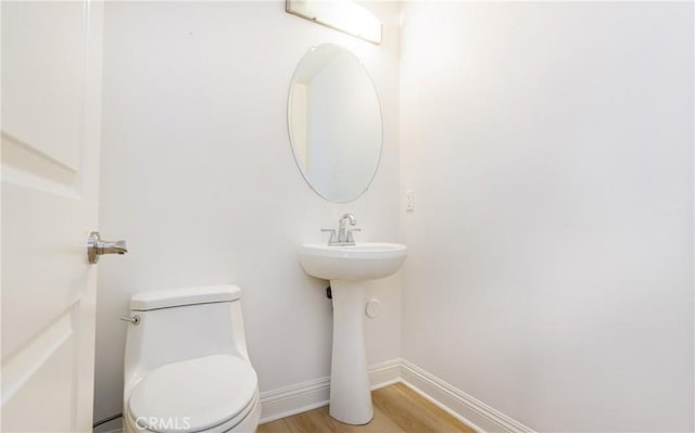 bathroom with toilet and hardwood / wood-style flooring