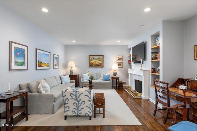 living room featuring dark hardwood / wood-style flooring and built in shelves