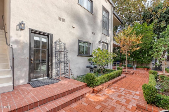 view of exterior entry featuring a patio