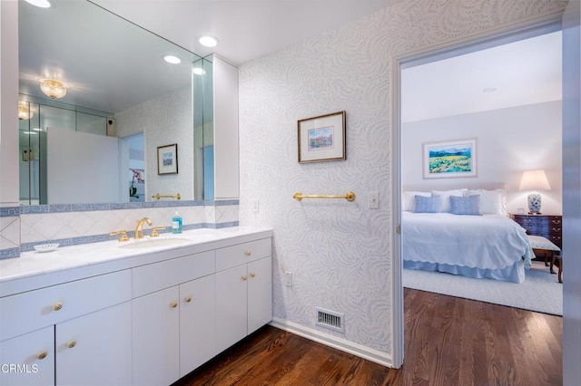 bathroom featuring wood-type flooring, backsplash, and vanity