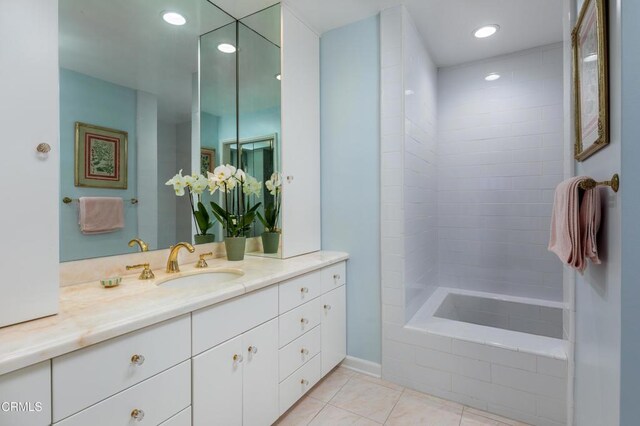 bathroom with vanity, tile patterned floors, and tiled tub