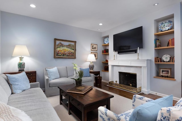 living room with built in features and a premium fireplace