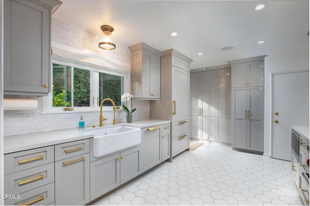 kitchen featuring gray cabinetry, decorative backsplash, and sink