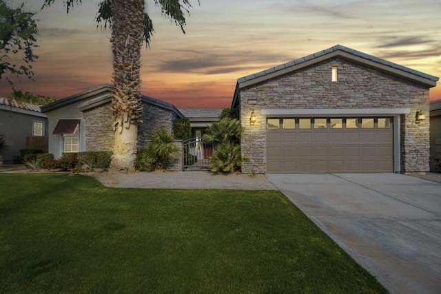 view of front of property with a garage and a yard