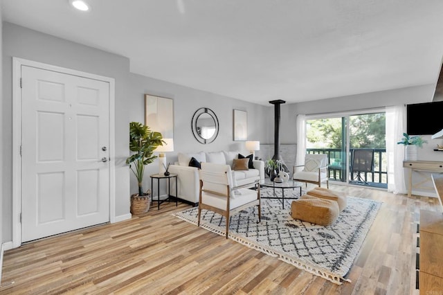 living room featuring light hardwood / wood-style floors and a wood stove