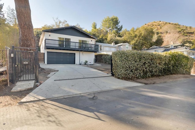 view of front facade featuring a balcony, a garage, and a mountain view