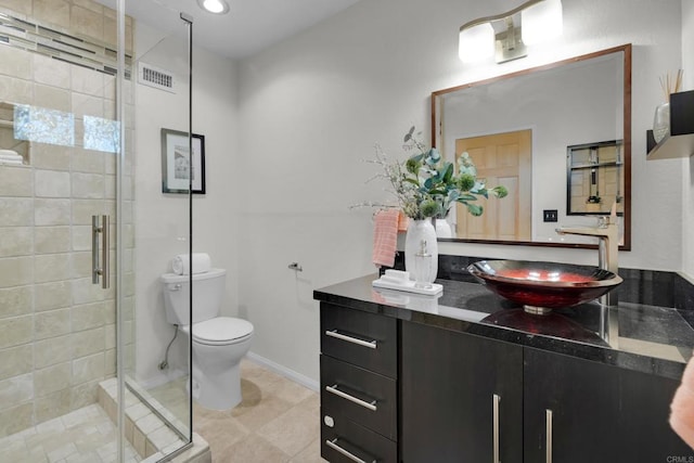 bathroom featuring vanity, toilet, tile patterned floors, and a shower with shower door