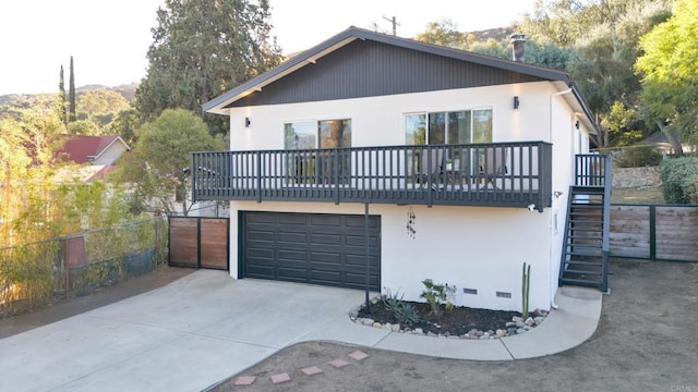 back of property with a balcony and a garage