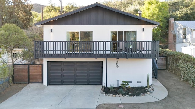 rear view of property featuring a garage and a balcony