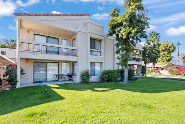 rear view of property with a patio area and a yard