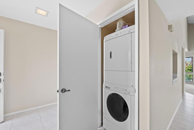 clothes washing area featuring stacked washer / dryer and light tile patterned floors