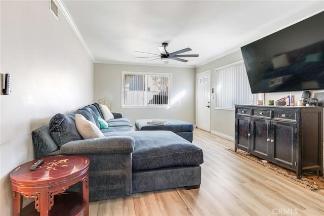 living room with ceiling fan, ornamental molding, and light hardwood / wood-style floors