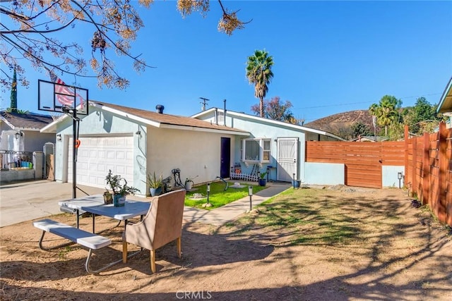 29801 Hursh St, Lake Elsinore, CA 92530 - rear view of house featuring stucco siding, a garage, fence, and driveway