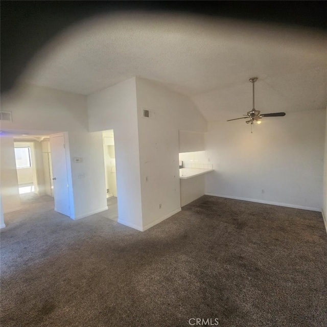 carpeted spare room featuring vaulted ceiling, ceiling fan, and a textured ceiling