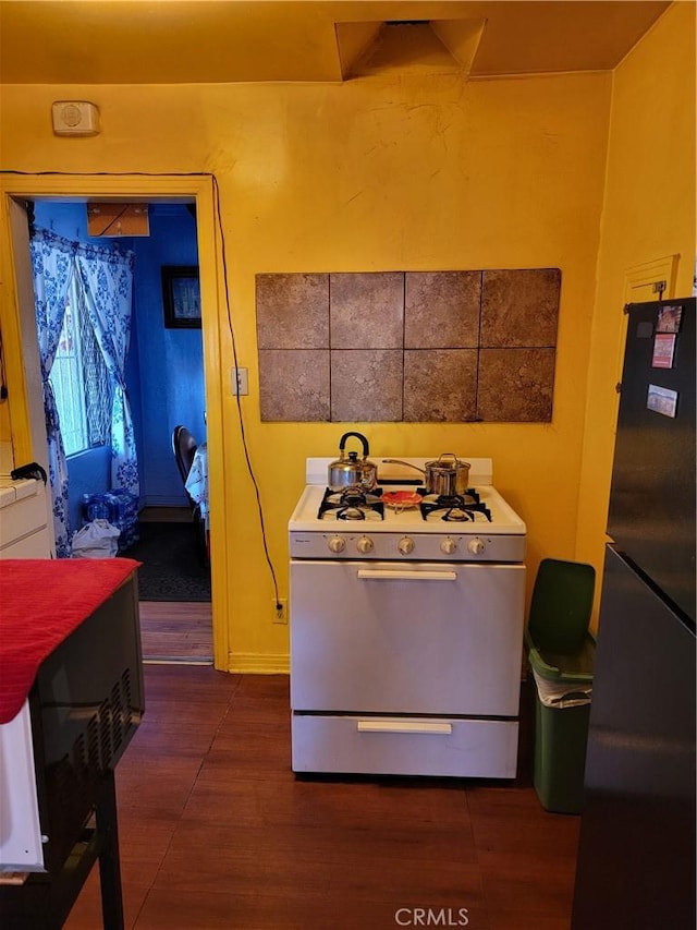 kitchen featuring gas range gas stove and black fridge