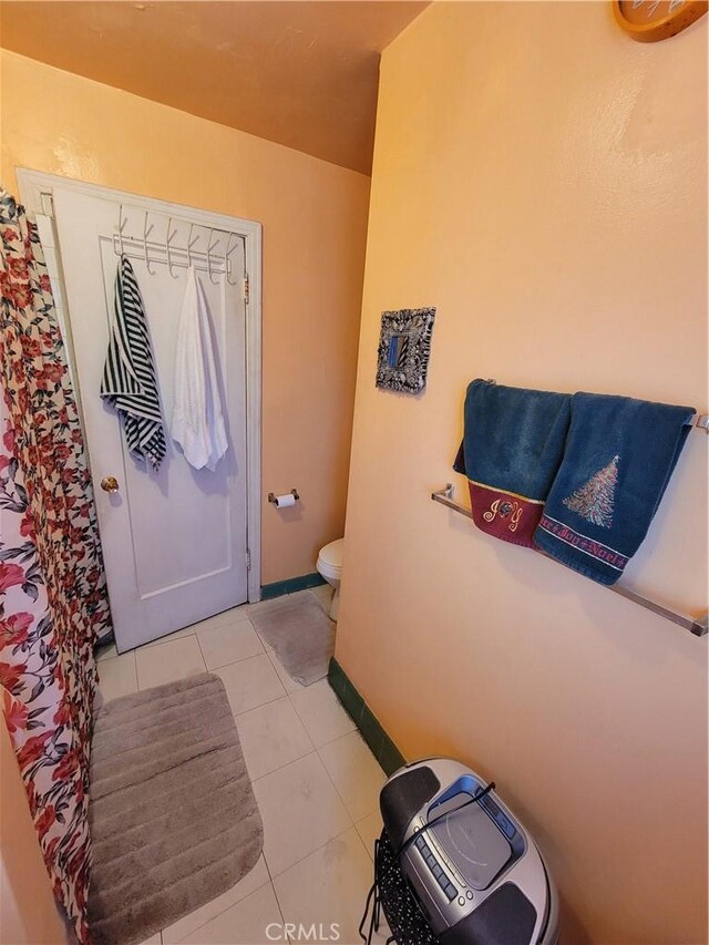 bathroom with toilet and tile patterned flooring