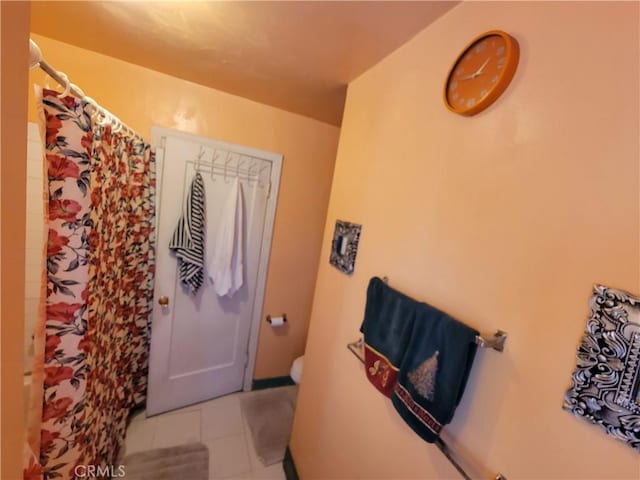 bathroom with tile patterned floors, walk in shower, and toilet