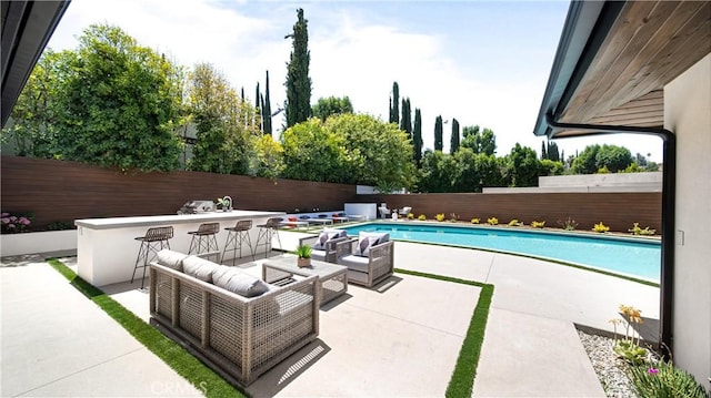 view of swimming pool featuring an outdoor bar and a patio