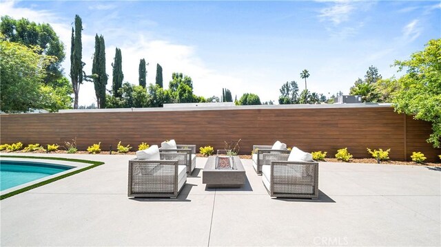 view of patio featuring an outdoor living space with a fire pit