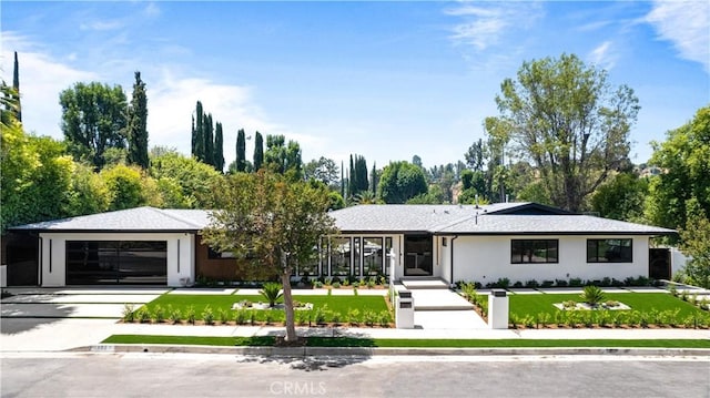 view of front of property featuring a front lawn and a garage