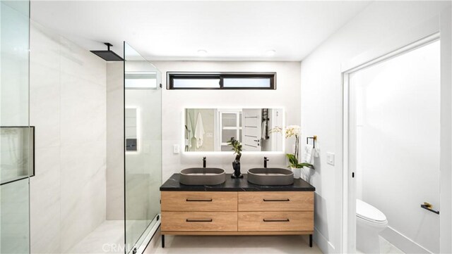 bathroom featuring toilet, baseboard heating, walk in shower, and vanity