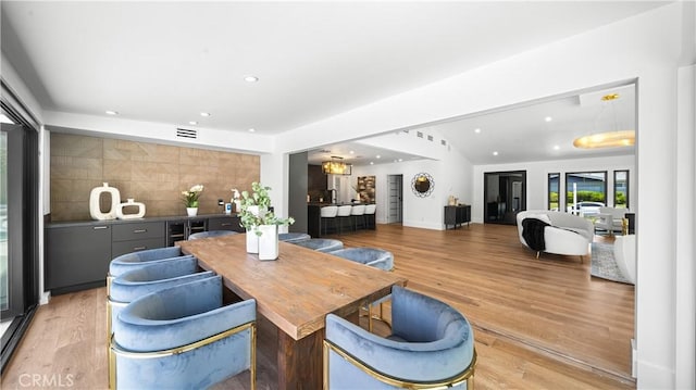 dining area featuring vaulted ceiling and light hardwood / wood-style floors