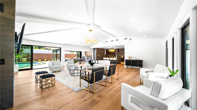 living room featuring lofted ceiling with beams and light wood-type flooring