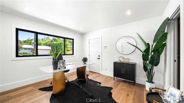 home office with light hardwood / wood-style floors