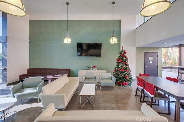 living room featuring concrete floors and a high ceiling