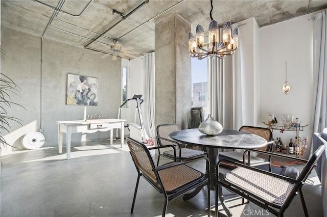 dining room with an inviting chandelier and concrete flooring