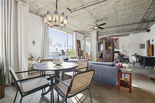 dining room featuring ceiling fan with notable chandelier and concrete flooring