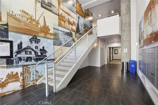 stairs featuring a mail area and a towering ceiling