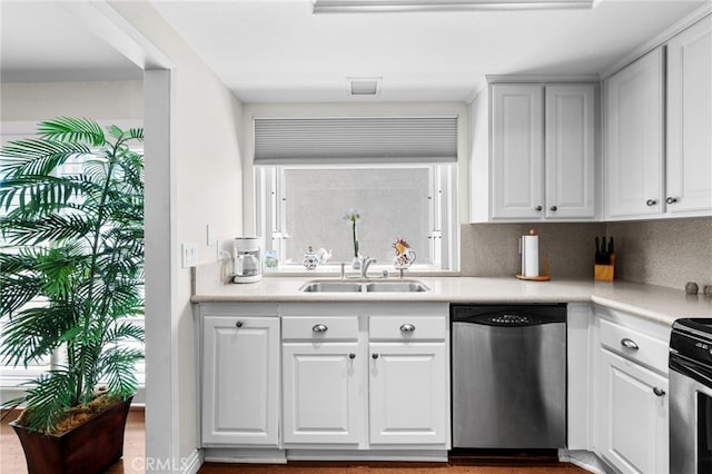 kitchen featuring decorative backsplash, sink, white cabinets, and appliances with stainless steel finishes