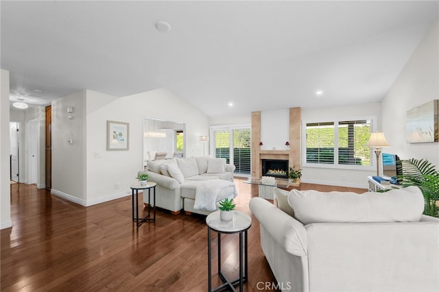 living room featuring a large fireplace, dark wood-type flooring, and lofted ceiling