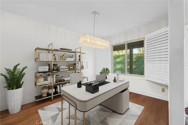 office area with hardwood / wood-style floors and an inviting chandelier