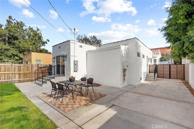 rear view of property featuring a patio and electric panel