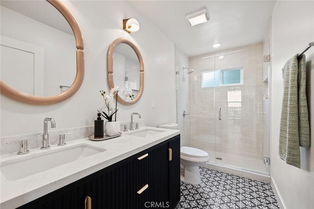 bathroom featuring vanity, toilet, and a shower with shower door