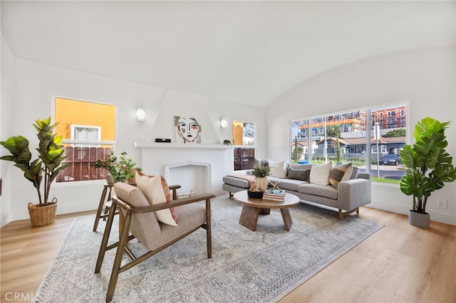 living room featuring brick ceiling, light hardwood / wood-style flooring, and lofted ceiling