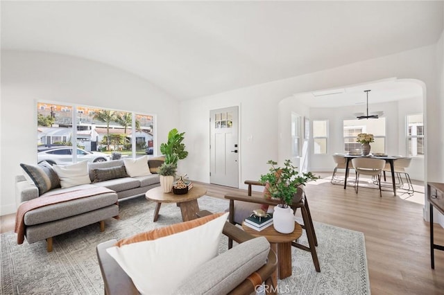 living room featuring hardwood / wood-style flooring, a wealth of natural light, lofted ceiling, and brick ceiling