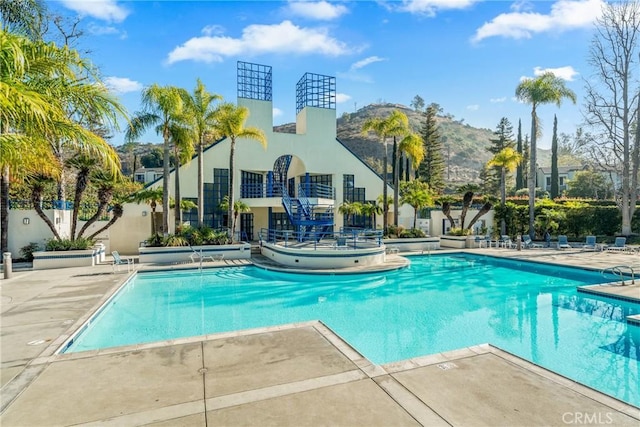 view of swimming pool with a patio area and a mountain view