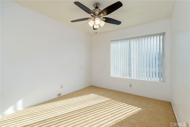 carpeted spare room with ceiling fan