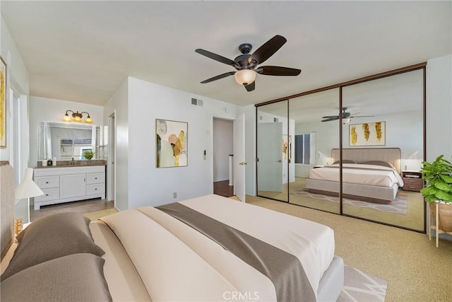 carpeted bedroom featuring ceiling fan and a closet