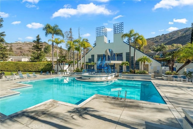 view of swimming pool featuring a patio area and a mountain view